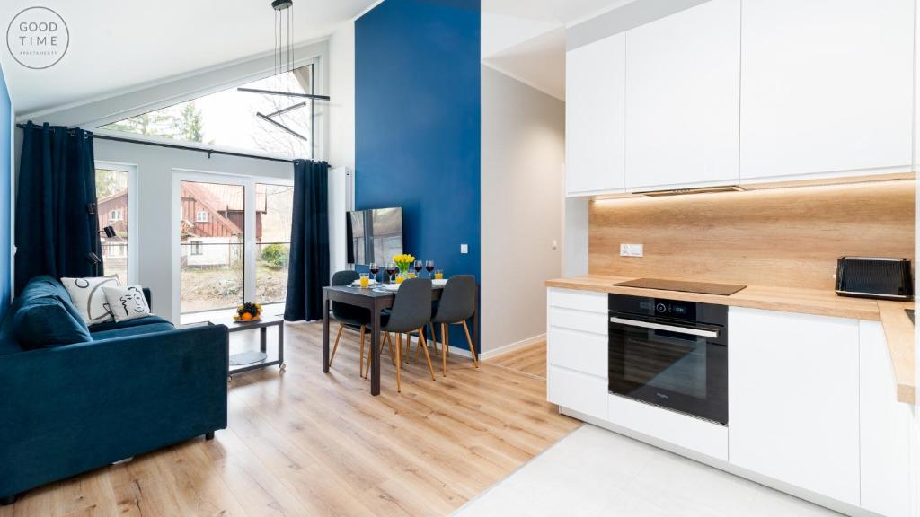 cocina y sala de estar con pared azul en Apartamenty Good Time - Osada Górska przy szlaku na Chybotek, en Szklarska Poręba