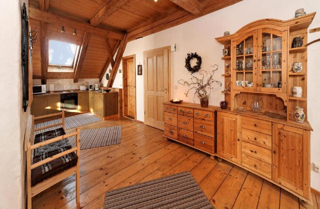 a large kitchen with wooden cabinets and wooden floors at Altes Forsthaus in Riedlhütte
