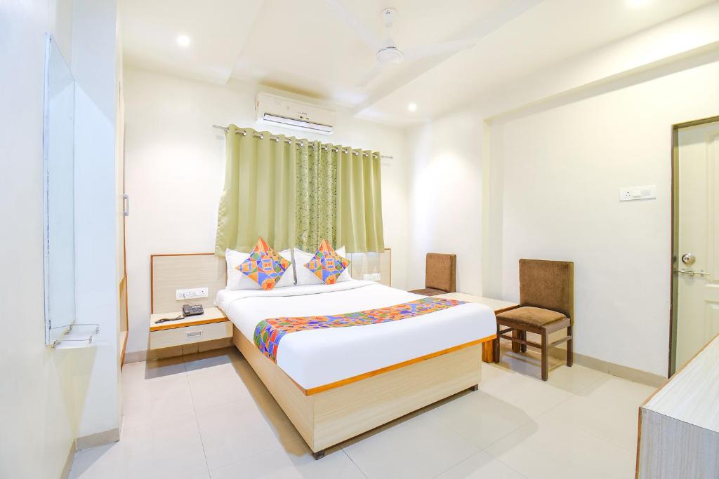 プネにあるFabHotel Ananta Sagarのベッドと窓が備わるホテルルーム
