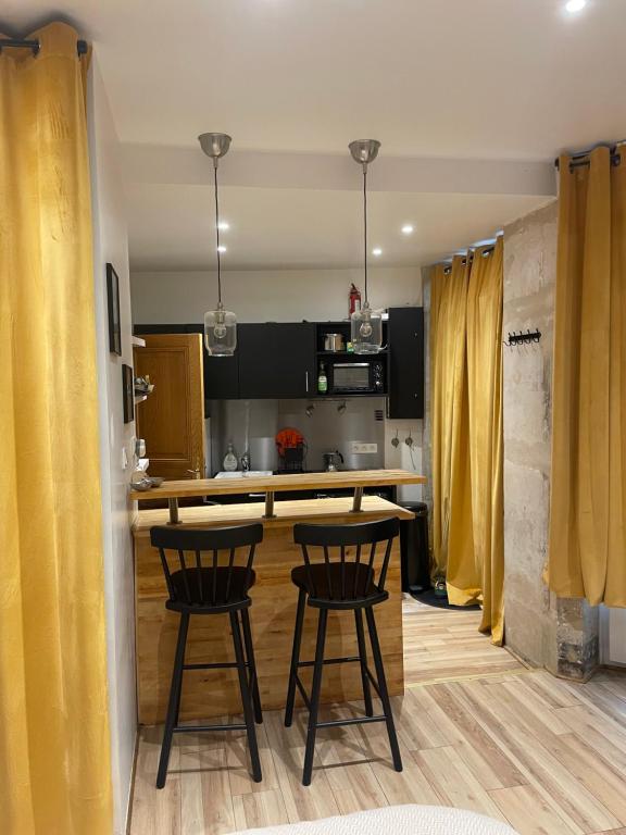 a kitchen with two bar stools and a kitchen island at Superbe Studio Montmartre, rue des Abbesses in Paris