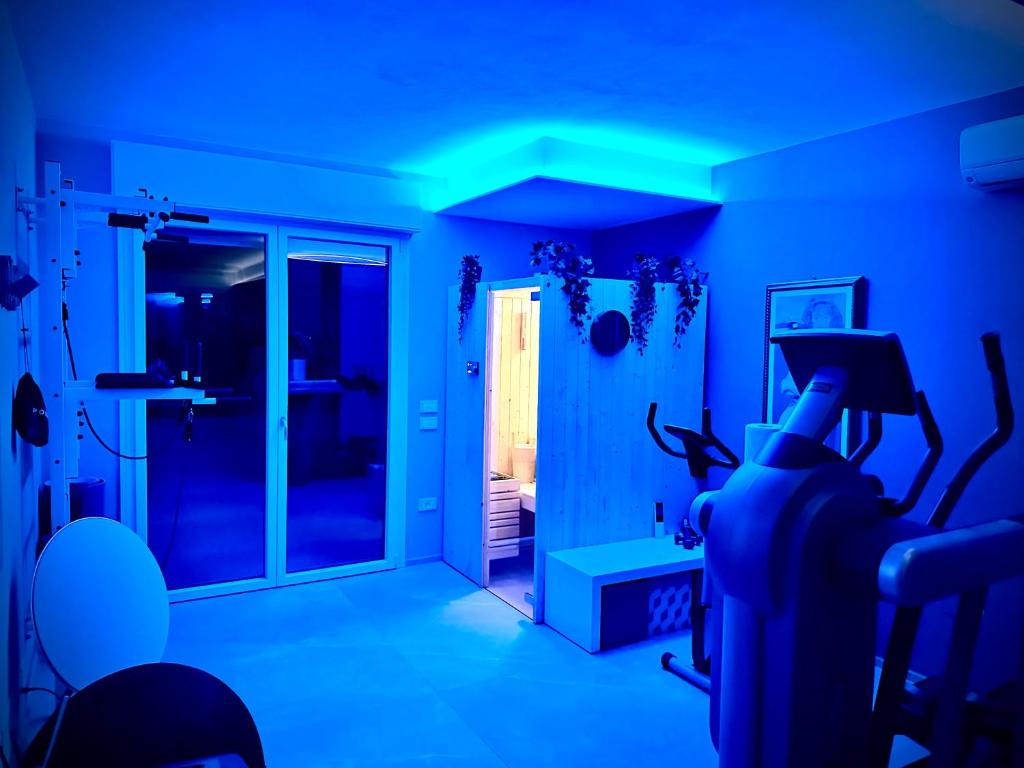 une chambre avec éclairage bleu et salle de sport dans l'établissement OliVia Home Sauna & Gym, à Forlì