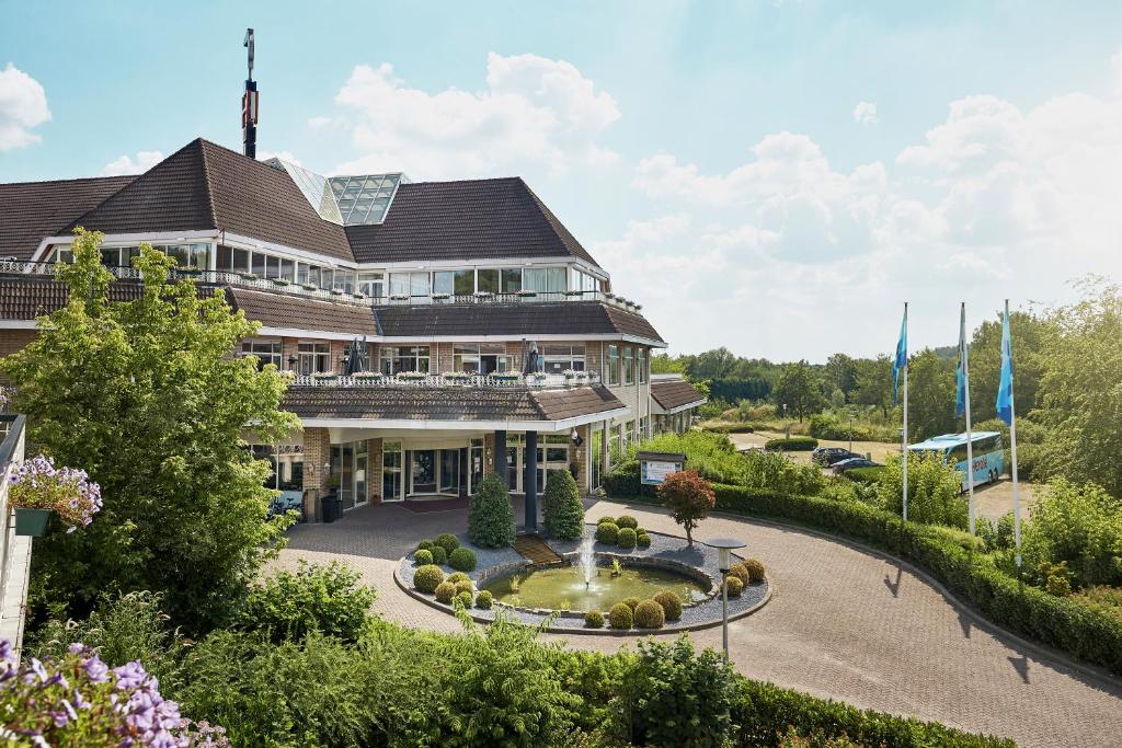 un grand bâtiment avec une fontaine devant lui dans l'établissement Hotel Gladbeck van der Valk, à Gladbeck