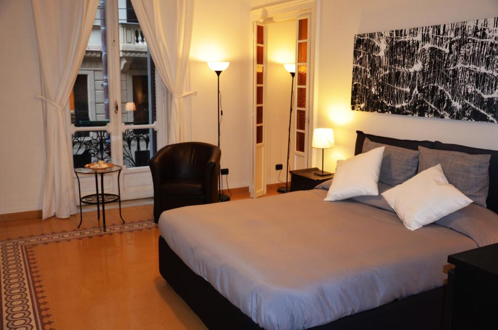 ナポリにあるResidenza Santa Luciaのベッドルーム1室(ベッド1台、椅子、窓付)