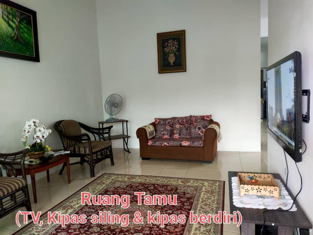a living room with a couch and a table at FJ Homestay in Seri Iskandar