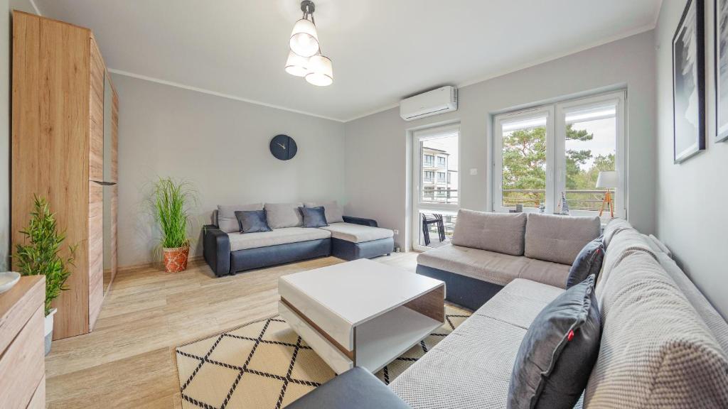 a living room with a couch and a table at Marynarska, Sun & Snow in Rowy