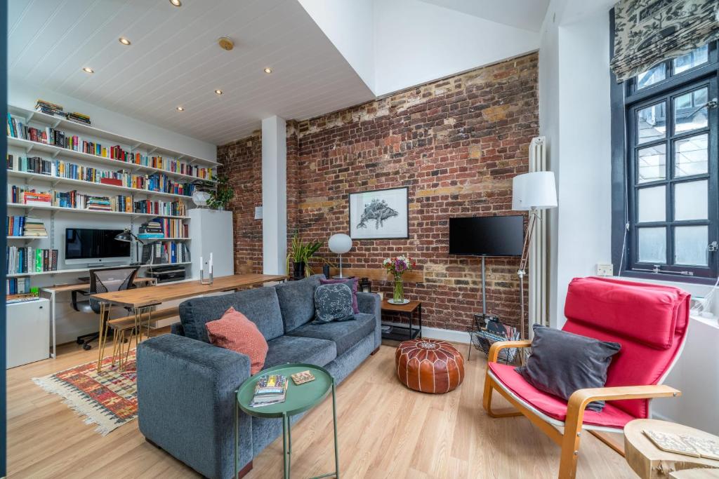 ALTIDO Stylish flat near London Bridge في لندن: غرفة معيشة مع جدار من الطوب
