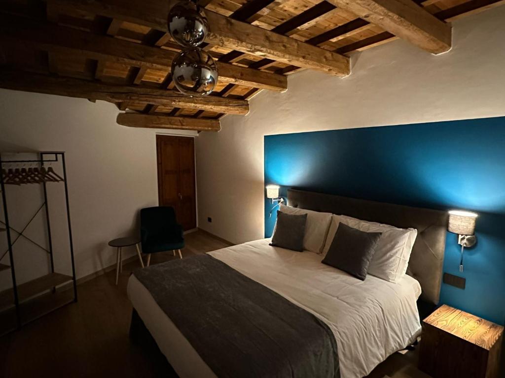 1 dormitorio con 1 cama grande y pared azul en Casa Plauto, en Sarsina