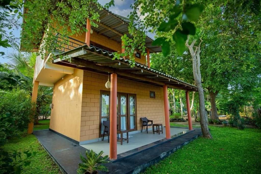 a small house with a porch and a table at Jim Dandy House in Tissamaharama