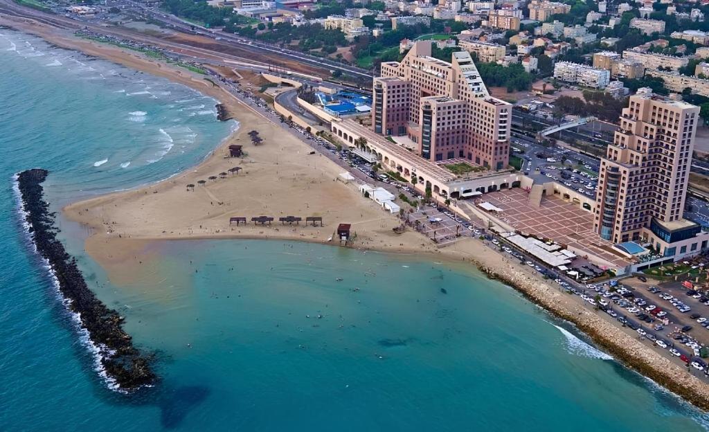 eine Luftansicht auf einen Strand neben dem Meer in der Unterkunft Almog Beach apt Hotel מלון דירות אלמוג ביץ' in Haifa