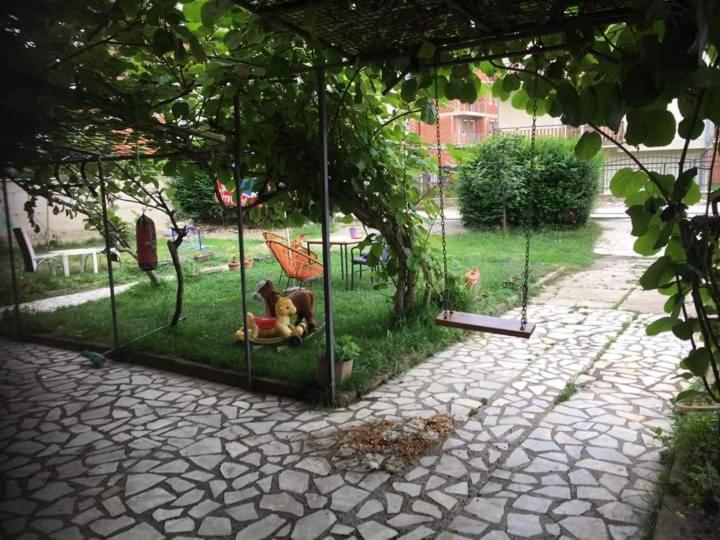 un jardín con un perro sentado en un columpio en Rooms Struga en Struga