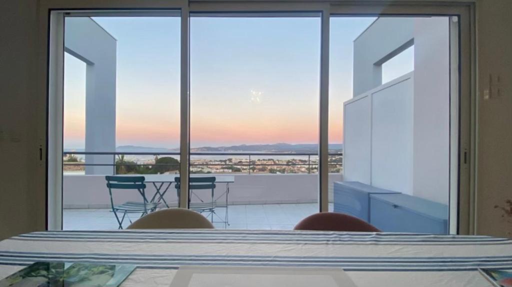 Habitación con vistas a un balcón con mesa y sillas. en SEA VIEW Classé 3 étoiles climatisé Terrasse Vue Mer Parking by LaConciergerie13, en La Ciotat