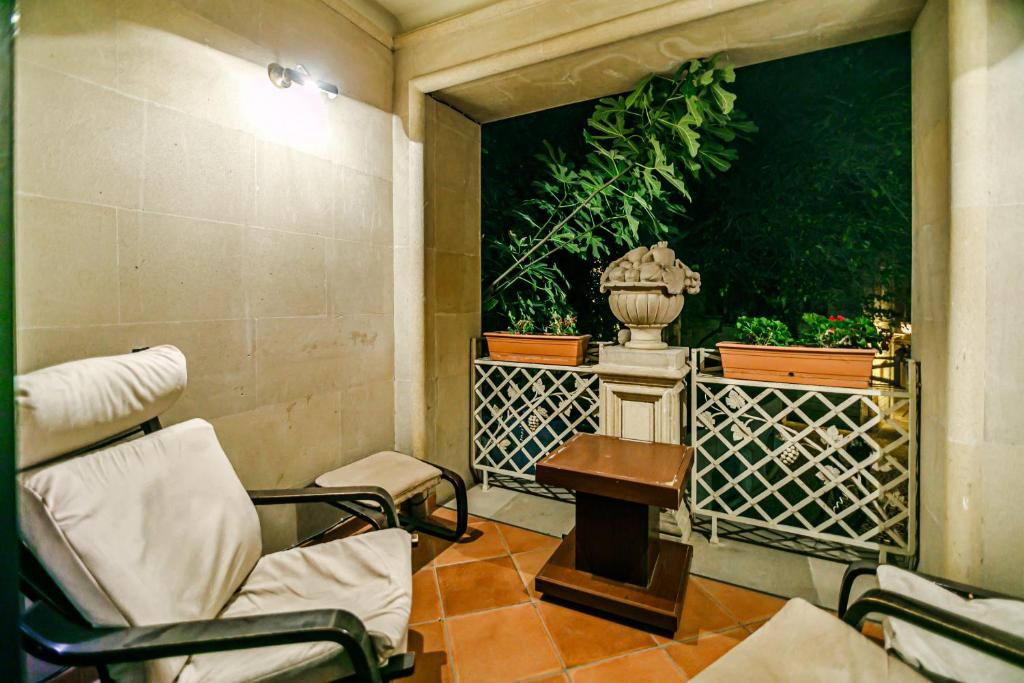 Zimmer mit 2 Stühlen, einem Tisch und einer Vase in der Unterkunft Deniz İnn Hotel in Baku