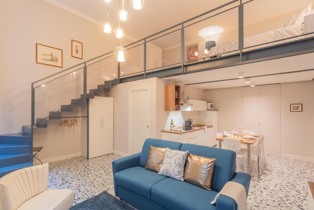 a living room with a blue couch and a staircase at Cinque Giornate 70 Suites by Rent All Como in Como