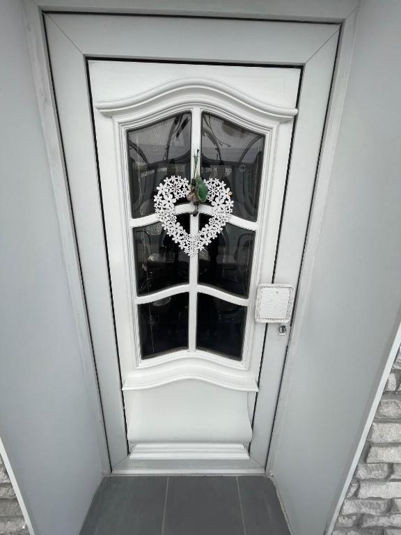 una puerta con una corona en forma de corazón en Möblierte Wohnung 2 Einzelzimmer, en Hünxe