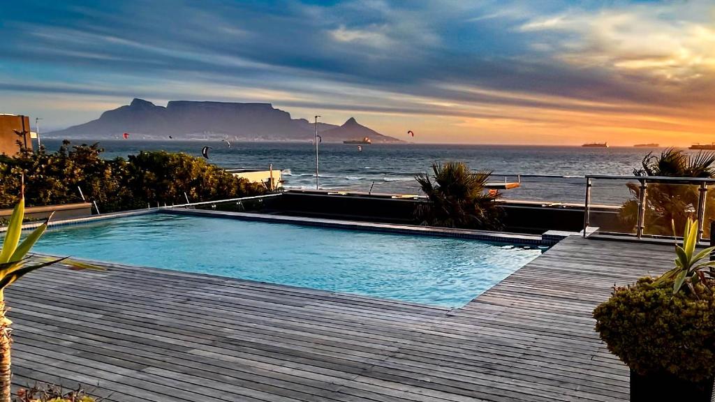 a swimming pool with a view of the ocean at Heaven on Earth - Blouberg Beachfront Self-catering Apartment in Bloubergstrand