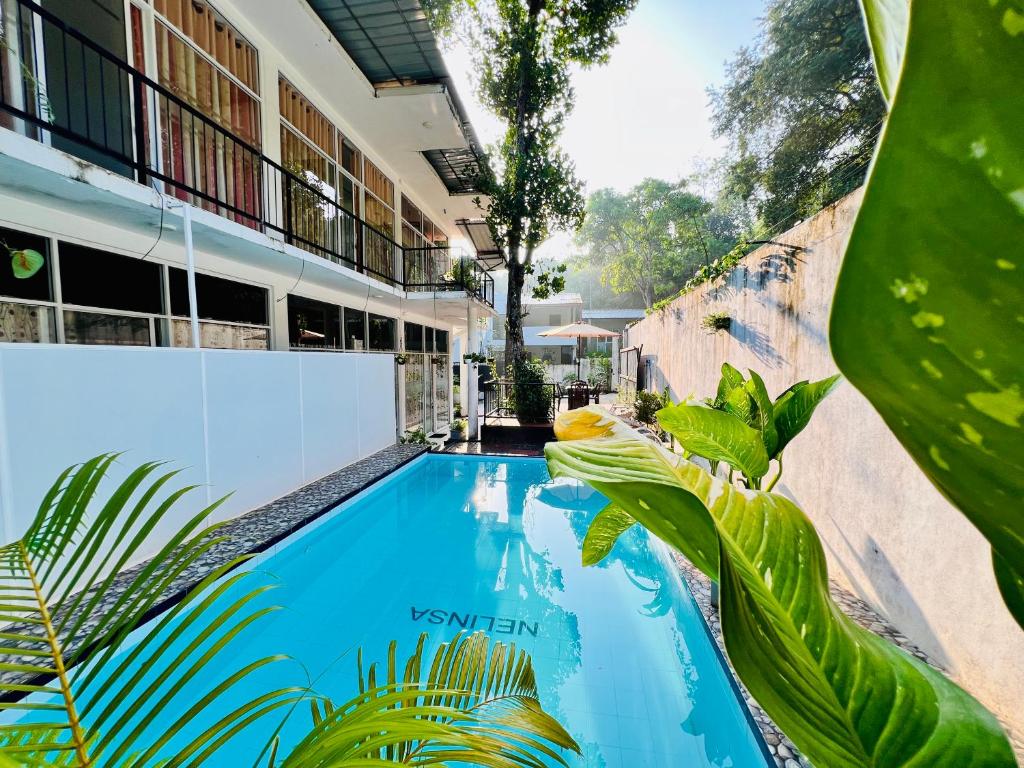 a swimming pool in front of a building at Eco Resort Kandy in Kandy