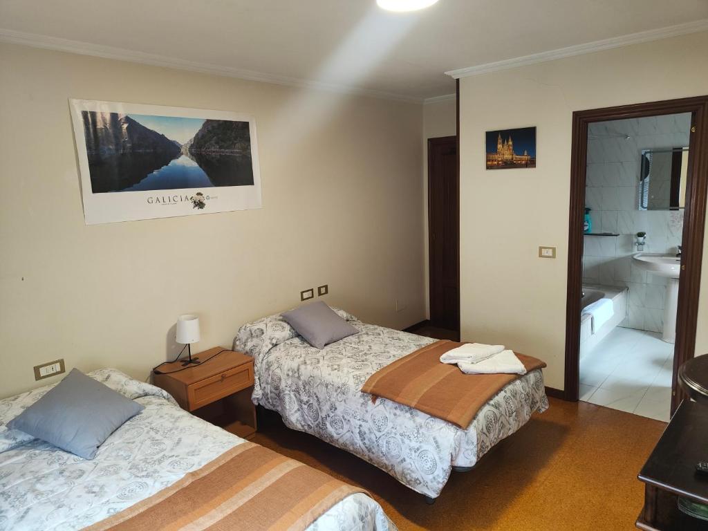 ein Hotelzimmer mit 2 Betten und einem Bad in der Unterkunft QUINTA ANDAINA in Sigüeiro