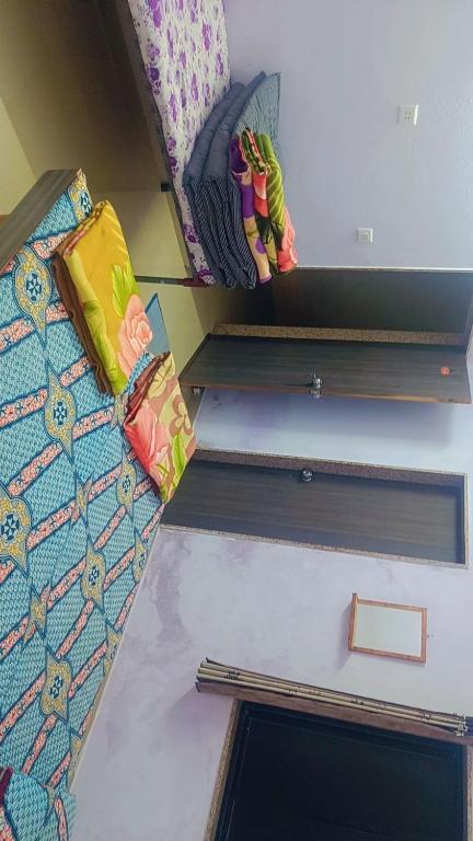 um quarto com duas prateleiras com almofadas em shree swaminarayan vishranti bhawan em Dwarka