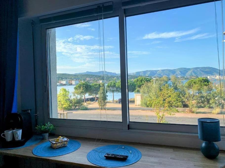 a room with a large window with a view of the water at Vue Mer sur l'isthme plage à 2 min. Arrivée H24 in La Seyne-sur-Mer