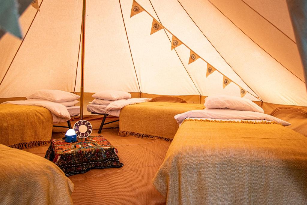 a room with three beds in a tent at Nine Yards Family Glamping @ Farrington's Farm in Bristol