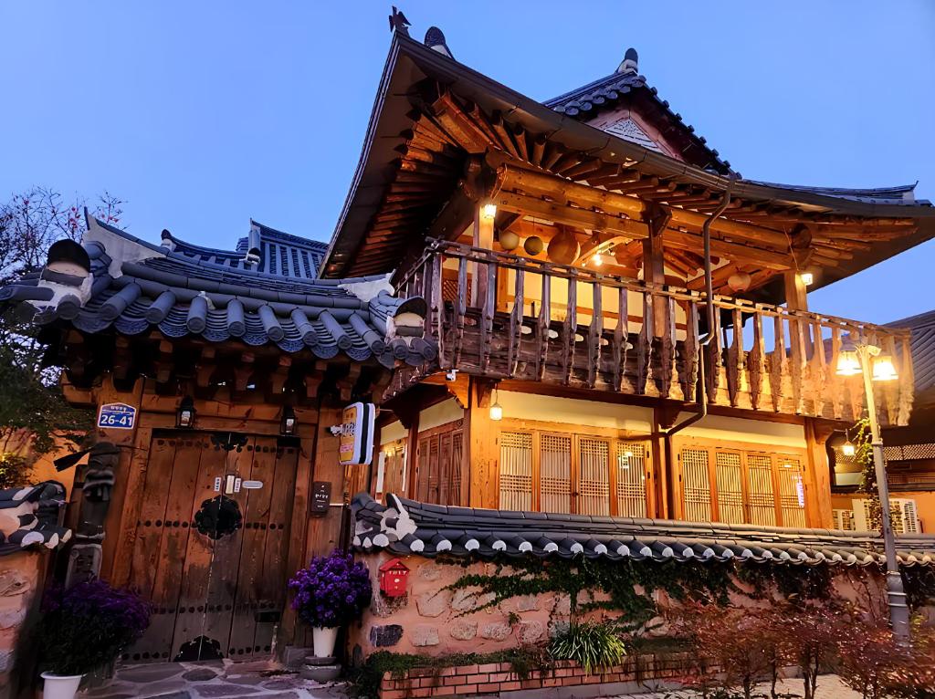 ein Holzhaus mit einem Balkon an der Seite in der Unterkunft Hanji Gguljam in Jeonju