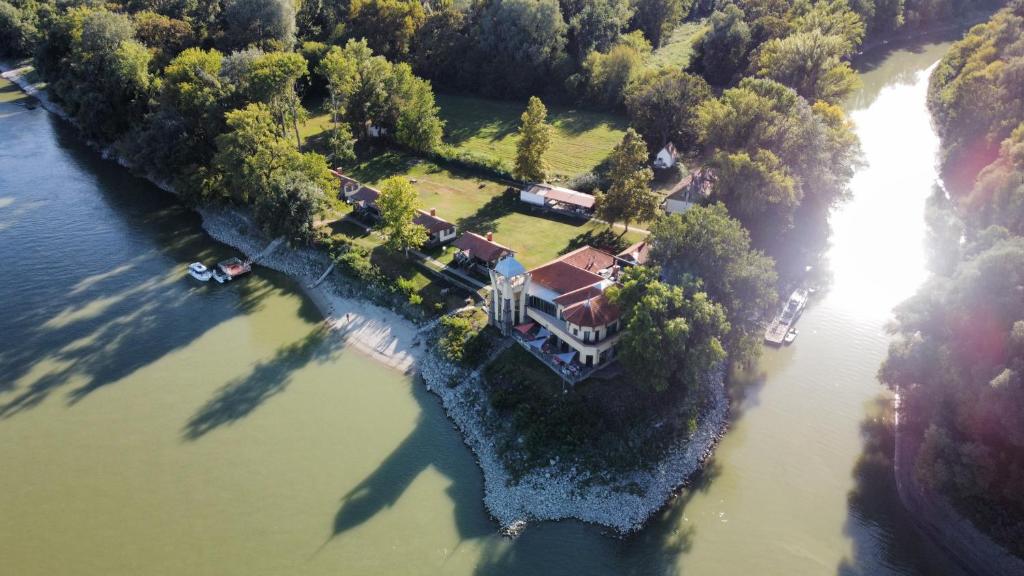 eine Luftansicht eines Hauses auf einer Insel im Wasser in der Unterkunft SZIGET HOTEL VERÁNKA in Érsekcsanád