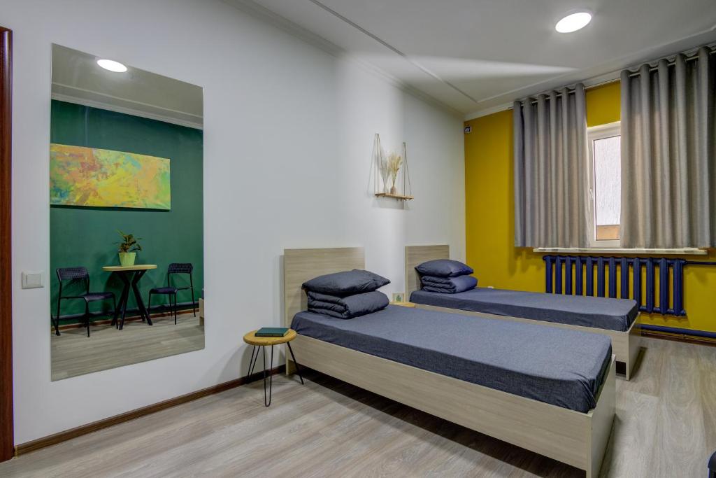 a bedroom with two beds and a table with chairs at People Hostel & Coworking in Bishkek