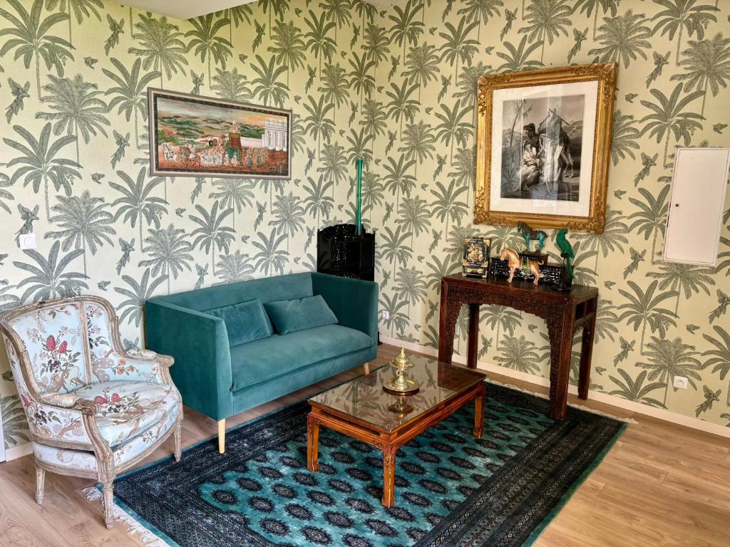 a living room with a blue couch and a chair at Château de la Pervenchère gîte Exotique in Casson