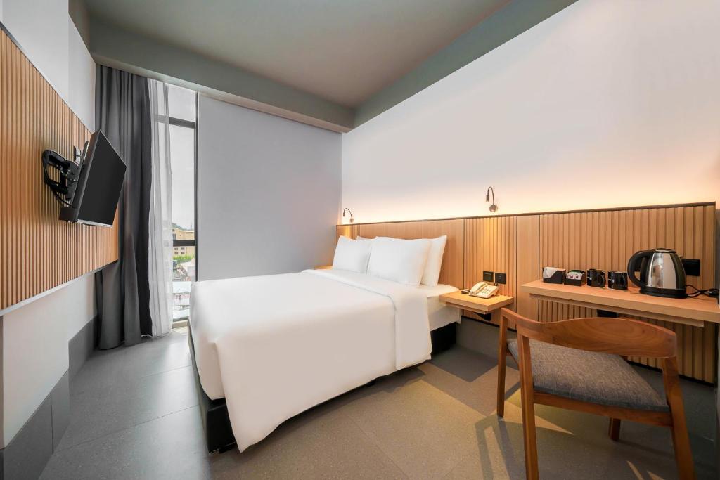 a hotel room with a bed and a desk and a chair at Ando Hotel Batam in Nagoya