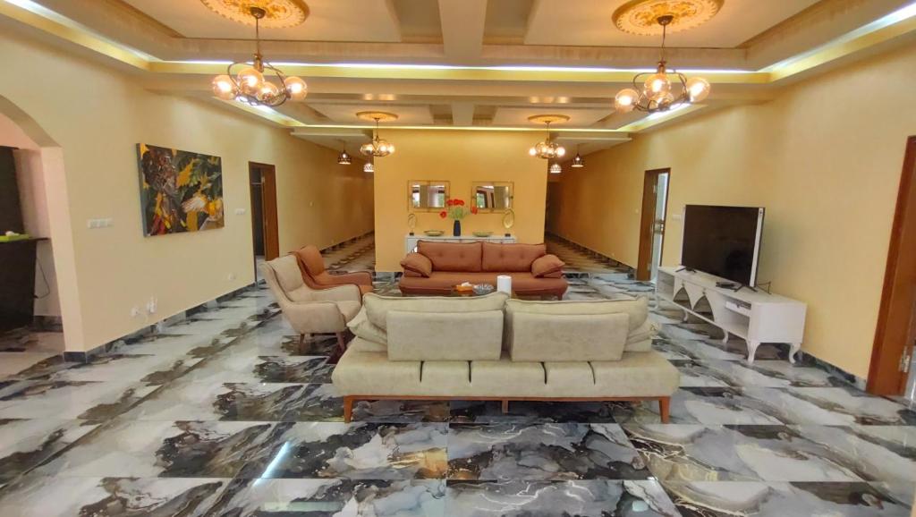- un salon avec un canapé et une télévision dans l'établissement Gaïa Luxury Suites, à Libreville