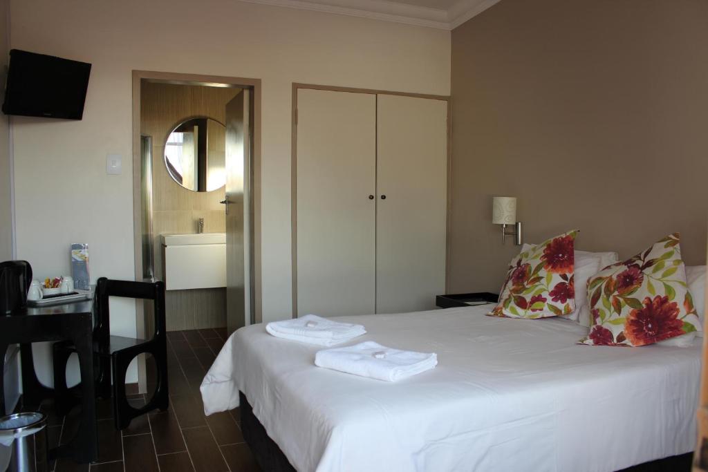 um quarto de hotel com uma cama com toalhas em Travel Lodge em Middelburg
