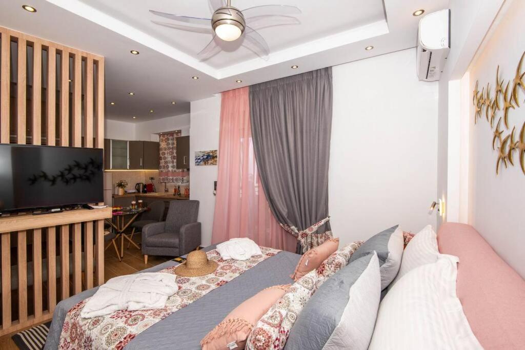 een slaapkamer met een bed, een tv en een bank bij LoveBirds Rethymno Suite in Rethimnon