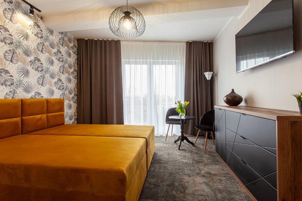een hotelkamer met een bed en een raam bij Bursztynowa Przystań in Grzybowo