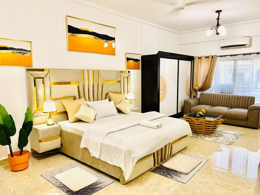 een slaapkamer met een groot bed en een bank bij Apartment in Dar es salaam , Mikocheni in Dar es Salaam