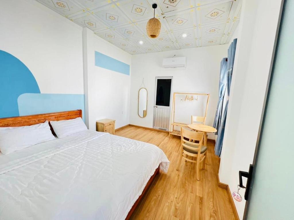 1 dormitorio con cama blanca y mesa en Homestay Phúc Lộc Phú Qúy, en Cu Lao Thu