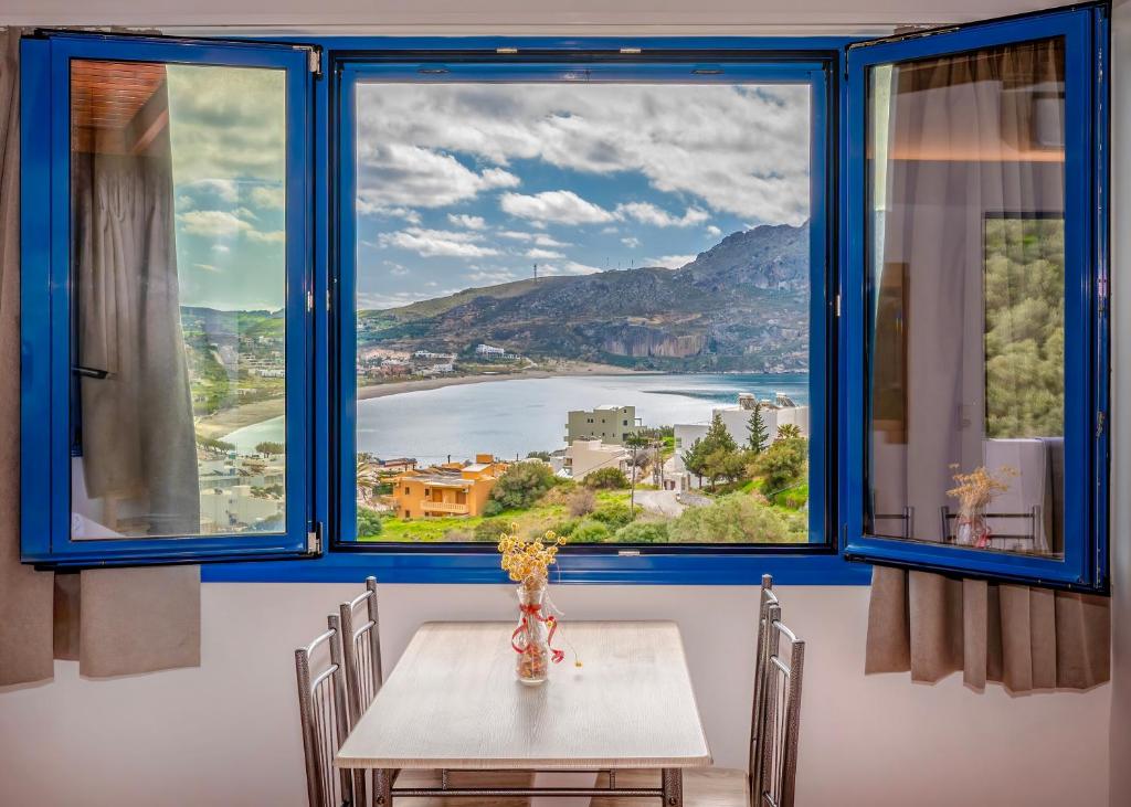 a dining room with a table and a large window at Panorama Studios in Plakias