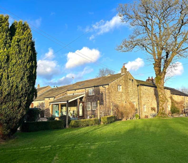 a large brick house with a green yard at The Barn, Roughlee in Barrowford