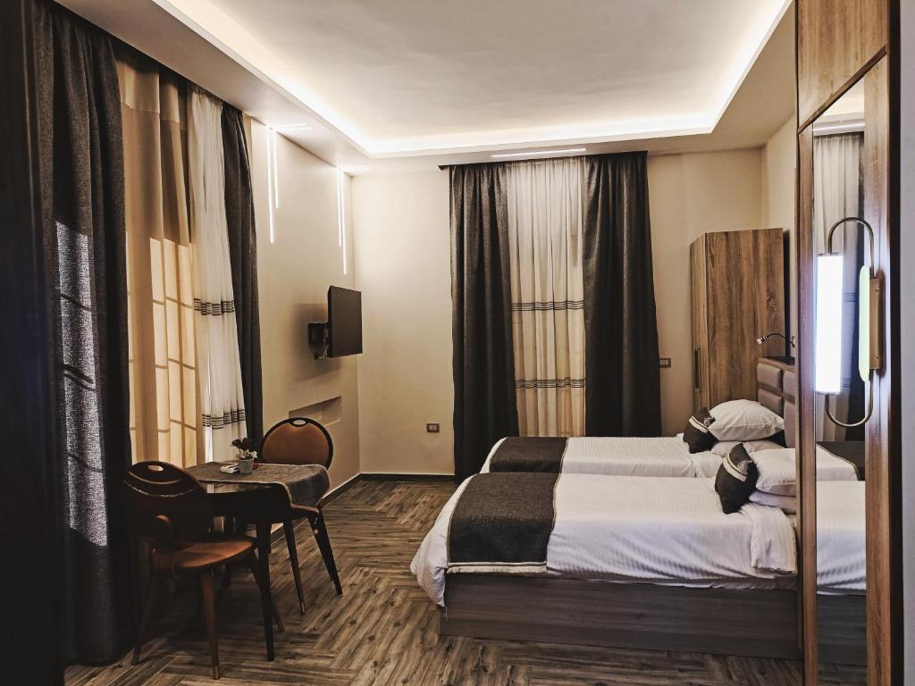 Sheikh ZayedにあるRoyal Elegance Roomのベッド2台とテーブルが備わるホテルルームです。