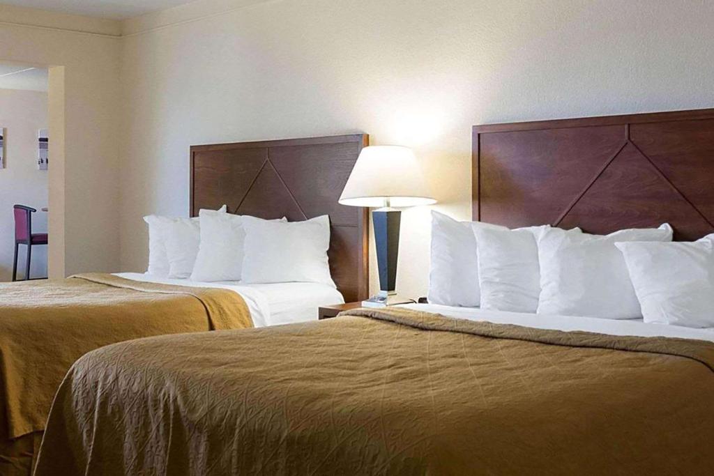 um quarto de hotel com duas camas com almofadas brancas em Baymont by Wyndham Jamestown Conference Center & Water Park em Jamestown