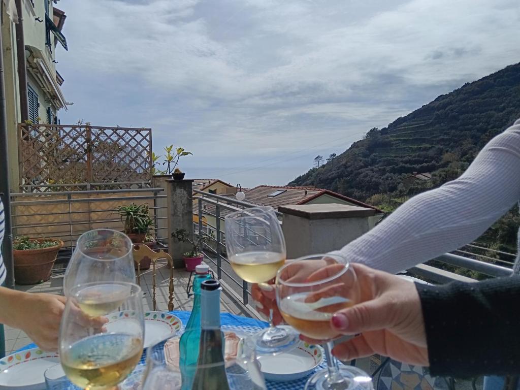 two people sitting at a table with glasses of wine at Le Terrazze di katia apartment in Riomaggiore
