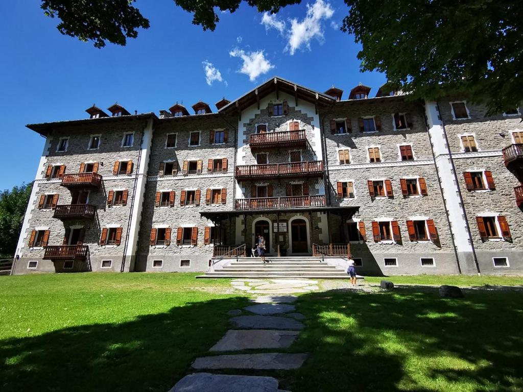 un gran edificio con gente parada frente a él en Grand Hotel Ceresole Reale studio apartment, en Ceresole Reale