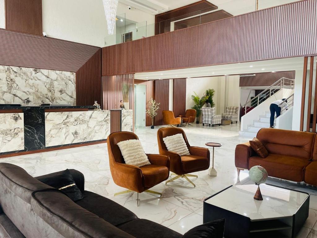 Tulun的住宿－LIA hotel- Lungi International Airport，带沙发和椅子的客厅以及壁炉