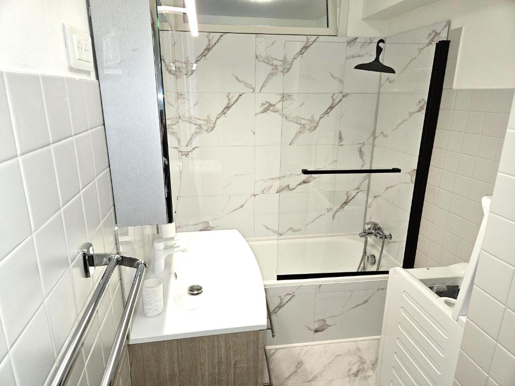 une salle de bain blanche avec lavabo et douche dans l'établissement Studio entre plages et Monaco climatisé parking, à Roquebrune-Cap-Martin