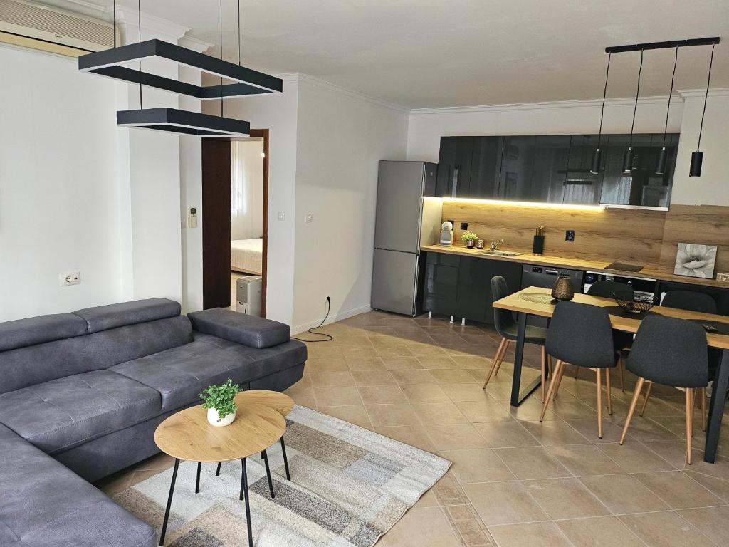 uma sala de estar com um sofá e uma mesa em Eve Santa Marina Apartments - sea, pools, relax em Sozopol
