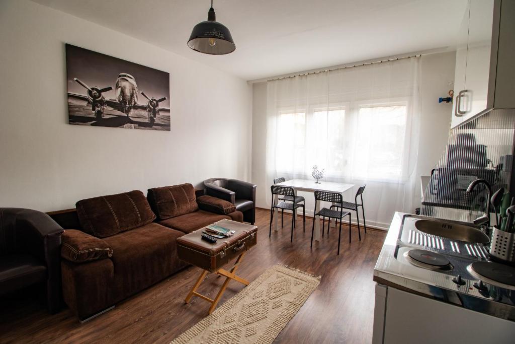 uma sala de estar com um sofá e uma mesa em LénApartman - Dakota em Pécs