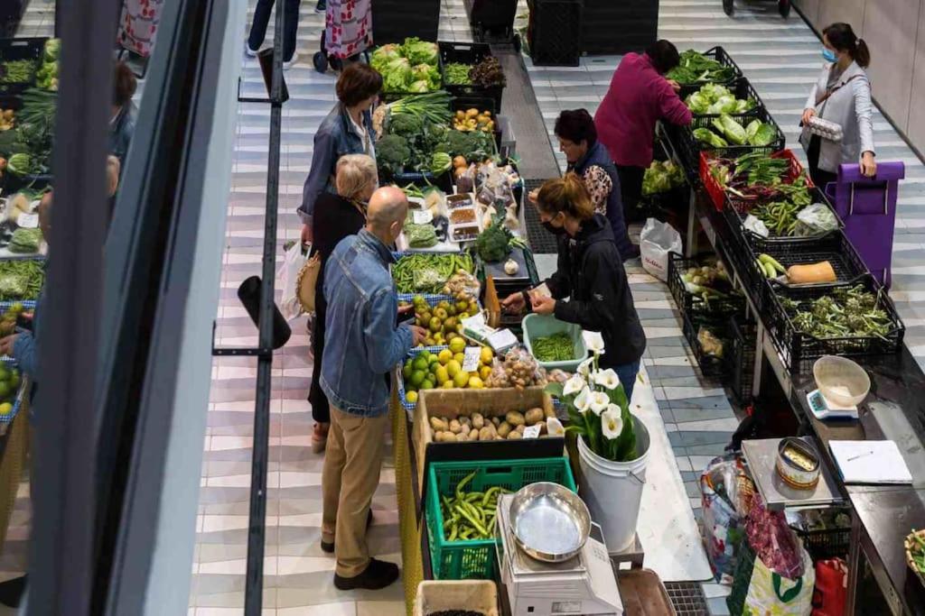 a group of people standing in a produce section of a market at Kareharri Piso en Casco Viejo de Zarautz in Zarautz