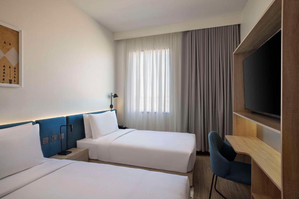 Postel nebo postele na pokoji v ubytování Hampton by Hilton Sharma NEOM Community 1