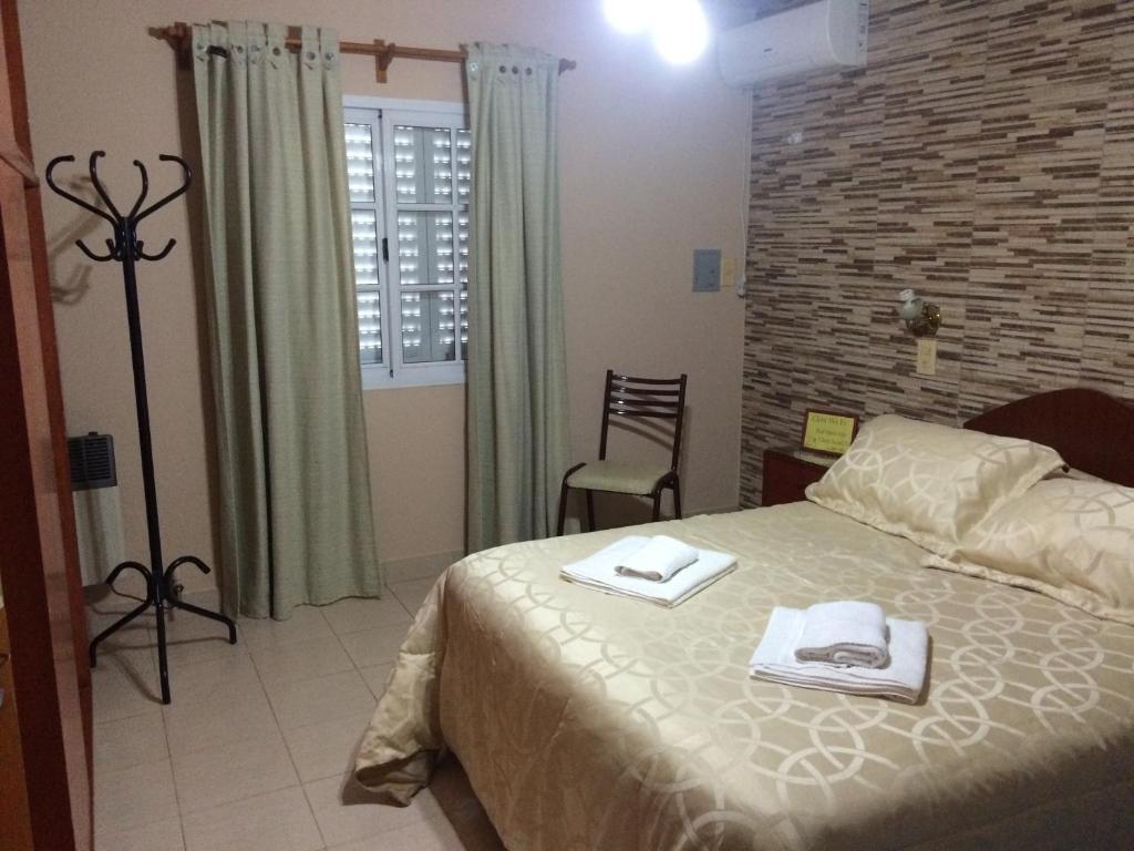 - une chambre avec un lit et des serviettes dans l'établissement Lo de Hilda, à Villa Elisa