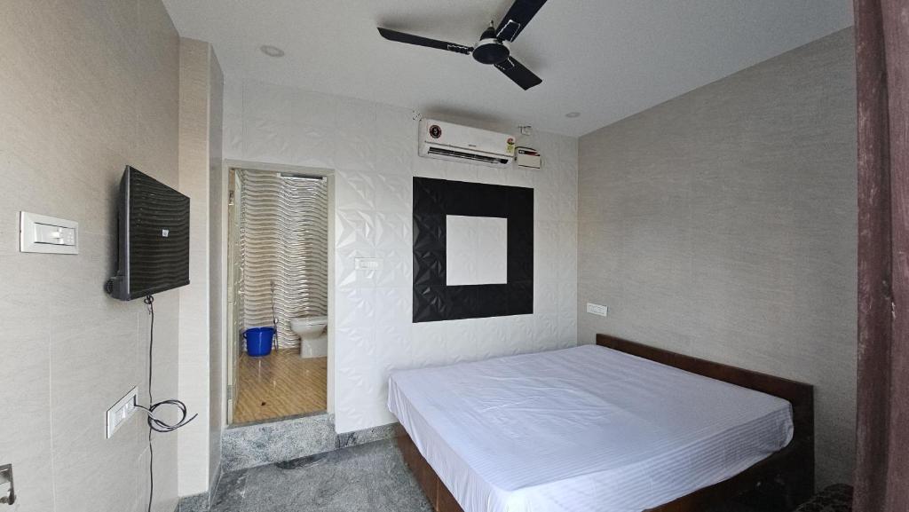 a bedroom with a bed and a television in it at MR.WHITE PRIME RESIDENCY in Chennai