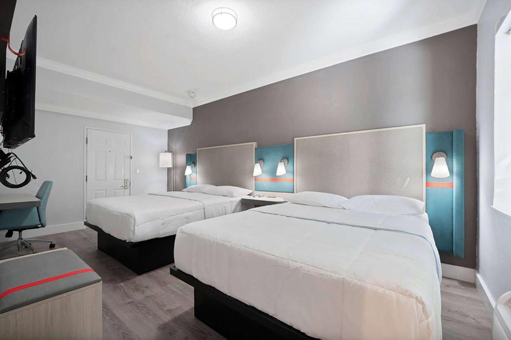 A bed or beds in a room at Garden Hotel Miami Airport, Trademark Collection by Wyndham